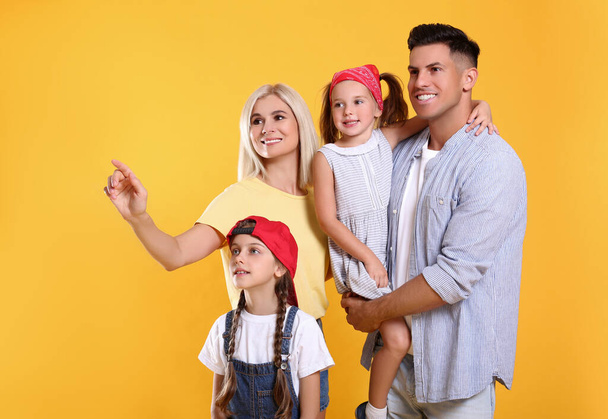 Portrait of happy family on yellow background - Foto, Bild