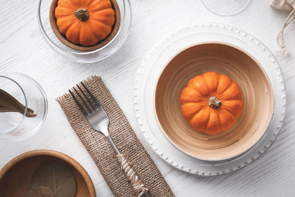 Autumn table setting with pumpkins on white wooden background, flat lay - 写真・画像