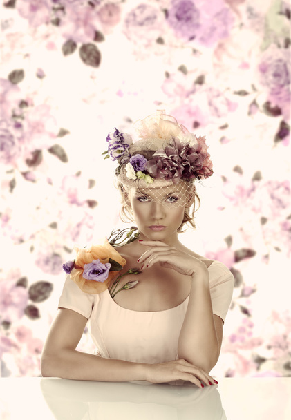 girl with flowers on the hat in front of the camera - Foto, Imagem