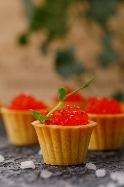 Appetizing tartlets with red caviar and microgreen decor. Holiday concept. - Foto, Bild