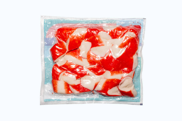 Viande de crabe dans un emballage sur fond blanc Viande de crabe à base de poisson blanc. - Photo, image