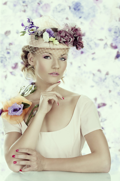 girl with flowers on the hat and hand under the chin - Foto, Imagen