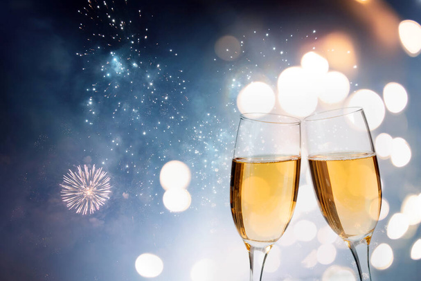 Glasses with champagne against fireworks and holiday lights - Photo, image