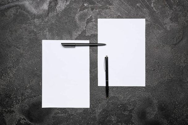 Koyu arkaplanda boş kağıt kağıtlar ve kalemler - Fotoğraf, Görsel