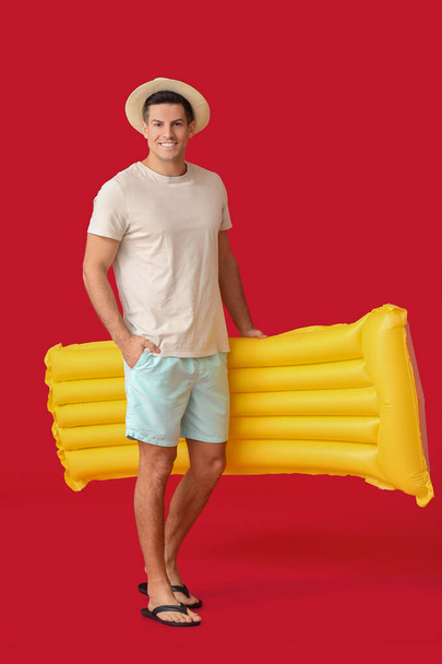 Young man with inflatable mattress on color background - Foto, Imagem