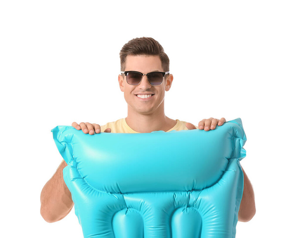Hombre joven con colchón inflable sobre fondo blanco - Foto, imagen