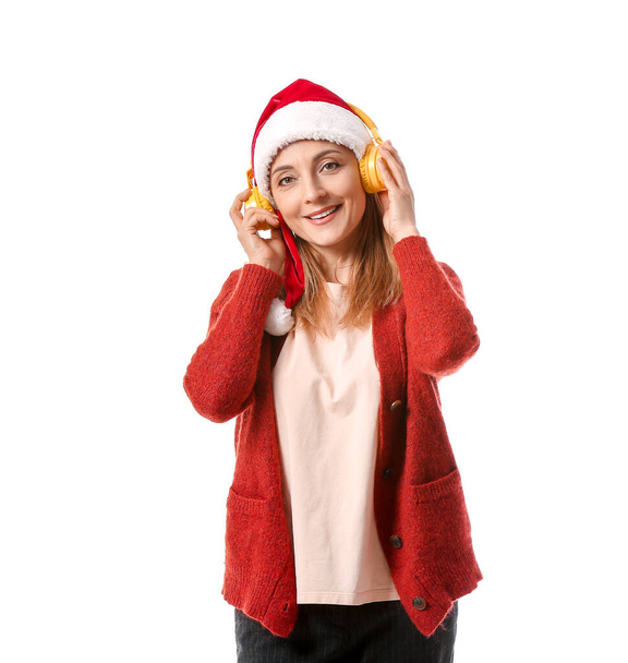 Mature woman listening to Christmas music on white background - Fotó, kép