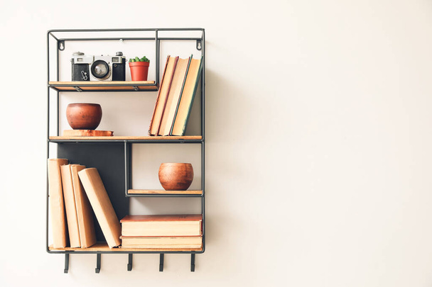 Shelf with books and decor on white wall - Fotoğraf, Görsel