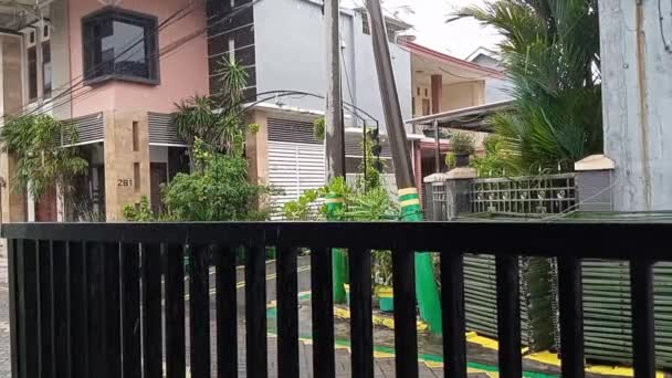 rain drops fall on concrete and black iron fence on the pedestrian street sidewalk in an urban area housing - Footage, Video