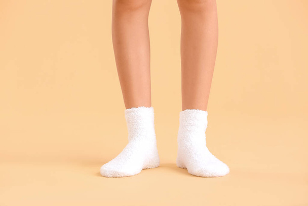 Legs of young woman in socks on color background - Φωτογραφία, εικόνα
