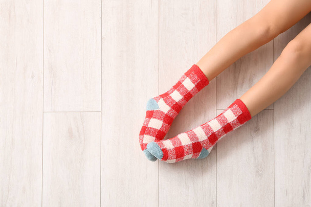 Πόδια νεαρής γυναίκας με κάλτσες σε ξύλινο φόντο - Φωτογραφία, εικόνα