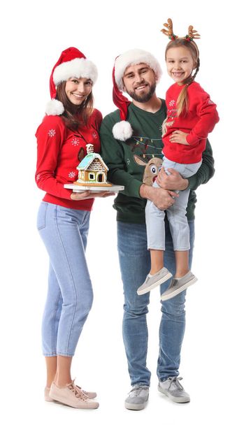 Familia feliz con casa de jengibre sobre fondo blanco. Celebración de Navidad - Foto, imagen