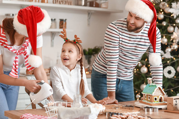 Ευτυχισμένη οικογένεια κάνει νόστιμα μπισκότα μελόψωμο στην κουζίνα την παραμονή των Χριστουγέννων - Φωτογραφία, εικόνα