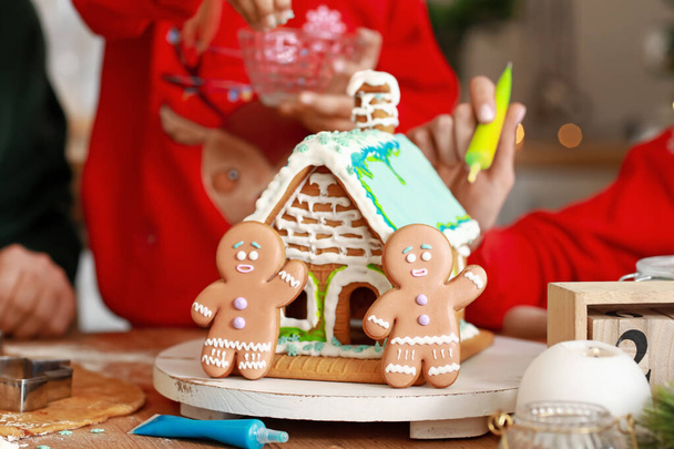 Perhe tekee maukasta piparkakkutaloa keittiössä jouluaattona - Valokuva, kuva