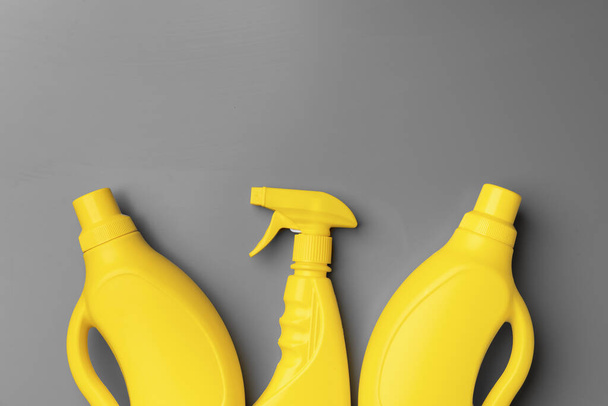 Yellow liquid detergents containers on gray background - Φωτογραφία, εικόνα