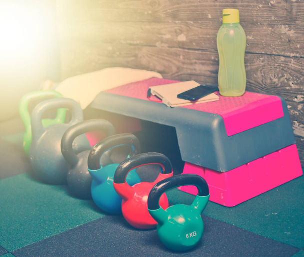 Set de pesas coloridas y otros equipos de ejercicio funcional en el floo del gimnasio - Foto, imagen
