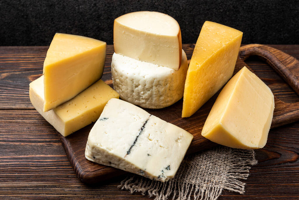 Cheese on dark wooden background. - Φωτογραφία, εικόνα