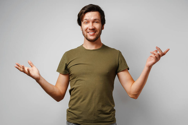 Clueless young man gesturing i dont know against grey background - Photo, Image