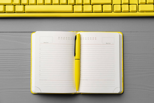 Yellow notepad on gray wooden background top view - Valokuva, kuva