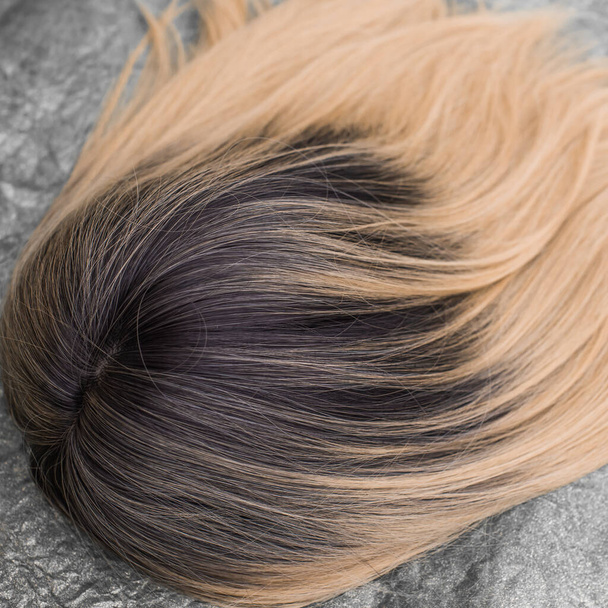 Perücken, natürliche und synthetische Haare. Das Schönheitskonzept der Frauen. Nahaufnahme Foto von Perücke, Haare für Damen  - Foto, Bild