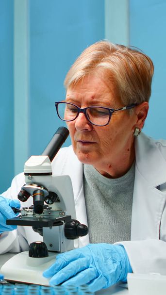 Mulher cientista de pesquisa olhando para amostras sob microscópio - Foto, Imagem