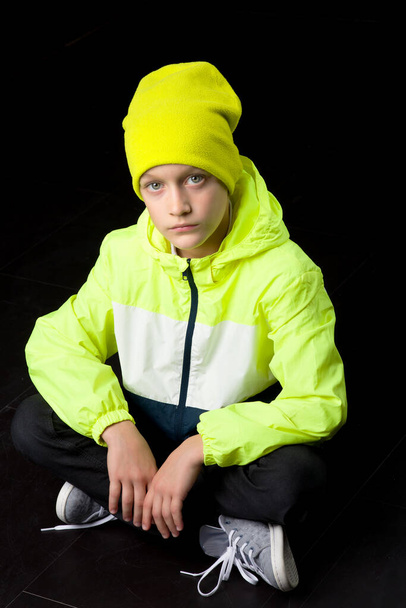Portrait of a boy sitting on the floor and looking at the camera - Fotoğraf, Görsel