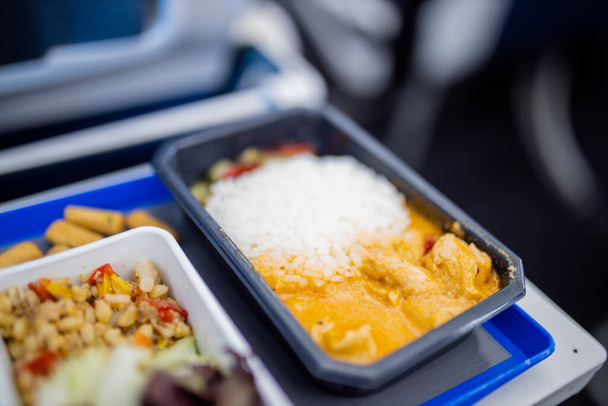 Airplane food on a gray and blue tray from above - Photo, Image