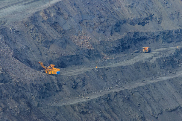 Gran cantera de mineral de hierro con camiones volquete de trabajo y excavadoras - Foto, imagen