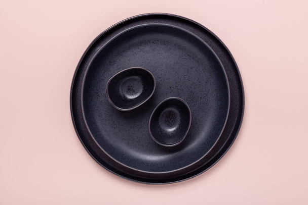 Set of black ceramic plates and gravy boats on pink background. Top view - Image - Photo, Image