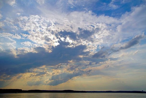    Летний вечер над озером. Прекрасное небо перед закатом. Горизонт облаков на открытом пространстве                             - Фото, изображение