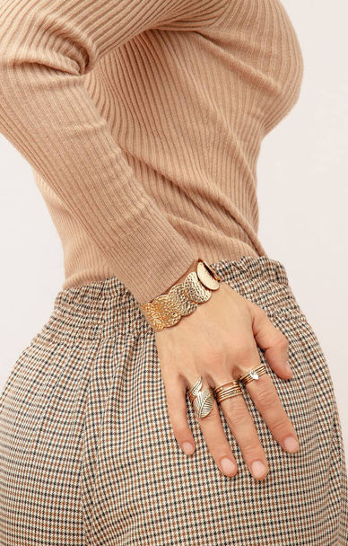 Paris retro Lady. Details of everyday look. Casual beige checkered paints and accessories jewelry rings and bracelets.  Trendy Minimalistic style. - Fotoğraf, Görsel