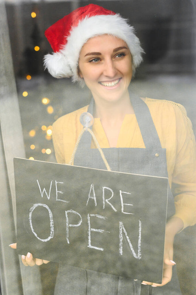 Young woman holding open sign in cafe - Foto, Imagem