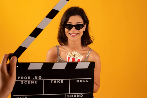 nő szemüveg és popcorn sárga háttér - Fotó, kép