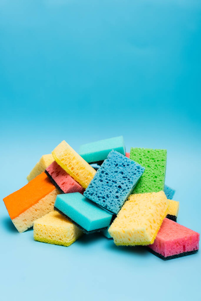 Pile of colorful sponges on blue background - Foto, imagen