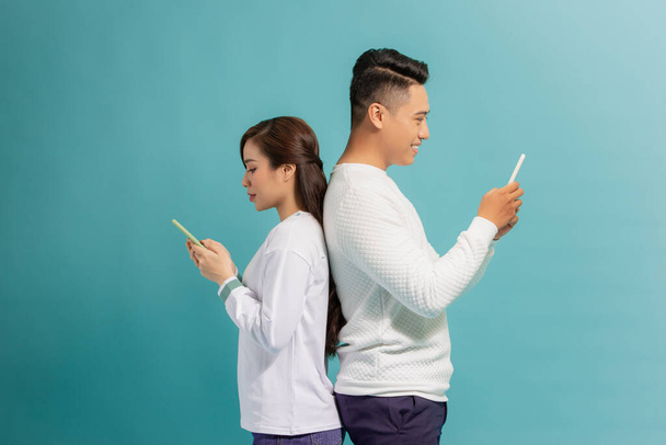 Angry boyfriend and girlfriend ignoring each other and using phone after argument - Photo, Image