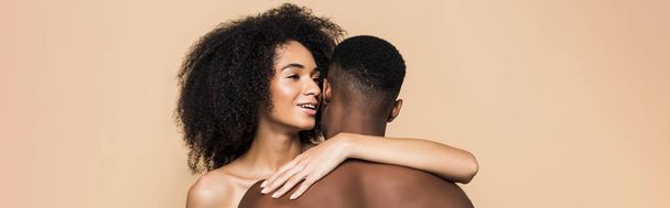 happy african american woman whispering in ear and embracing boyfriend isolated on beige, banner - Foto, immagini