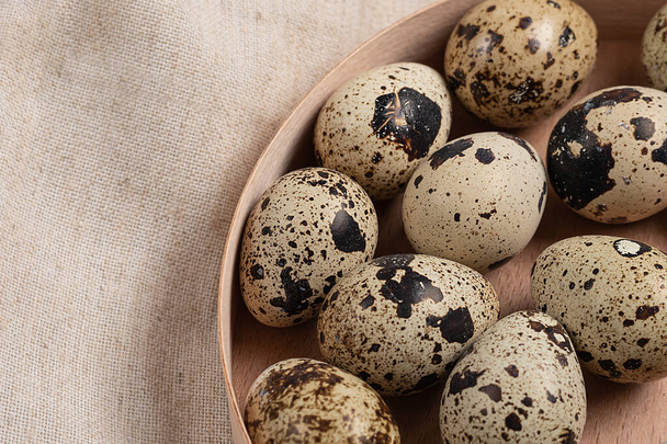 top view of quail eggs in round wooden box.Monochrome in food background - Foto, afbeelding
