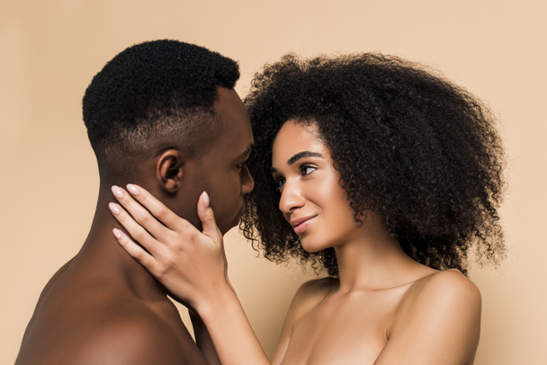 encaracolado afro-americano mulher tocando rosto de namorado isolado no bege  - Foto, Imagem