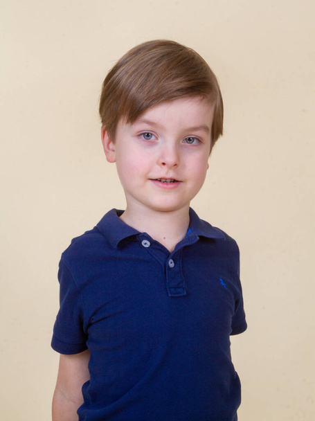Retrato de un niño lindo con el pelo rubio, un niño sonriendo, infancia feliz, apariencia de modelo. - Foto, Imagen