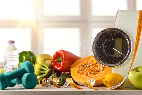 Healthy food and sport background on a white wooden table with scale and measuring tape with window background. Front view. Horizontal composition. - Zdjęcie, obraz