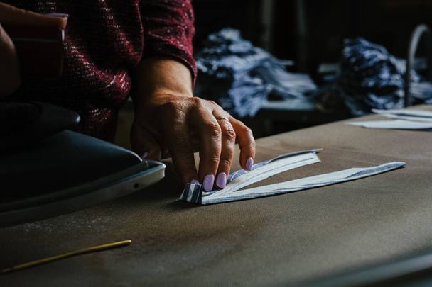 A selective focus shot of a seamstress working at a workshop - Photo, Image