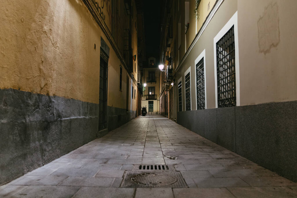 A view of an empty narrow pavement street at night - Фото, изображение