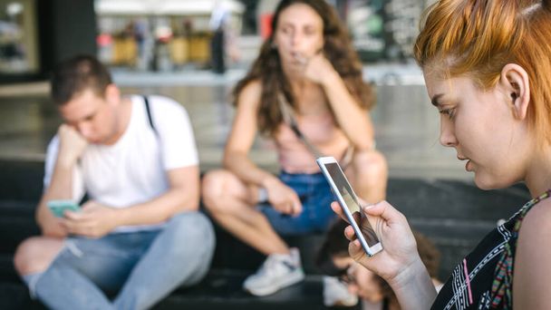 Group of friends using smartphones together. Young people addiction to new technology trends. Youth, new generation internet friendship concept. Emotional isolation and depresion - Foto, Imagen