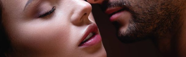 partial view of sensual woman face to face with man on dark background, banner - Photo, Image