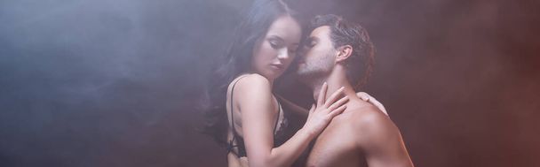 érzéki nő fekete csipke melltartó ölelés szexi férfi sötét háttér füst, banner - Fotó, kép