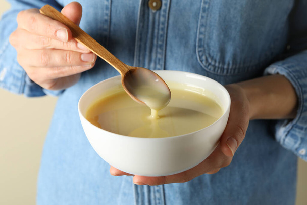 Woman hold bowl with condensed milk, close up - Photo, Image