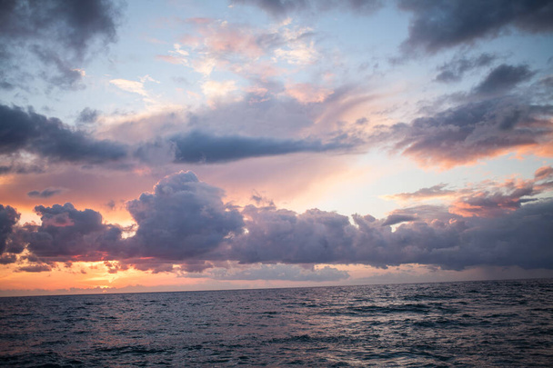 A landscape of the sea under a cloudy sky during a breathtaking sunset in the evening - Photo, image
