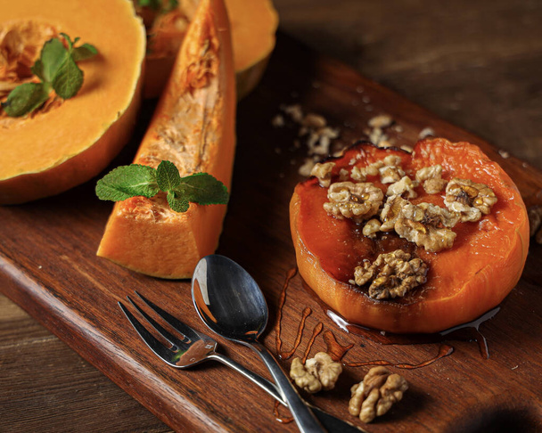 A closeup shot of oven baked pumpkin with walnuts and mint leaves on them - Φωτογραφία, εικόνα