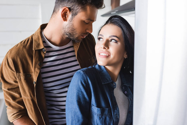 young couple in stylish casual clothes looking at each other at home - Fotoğraf, Görsel