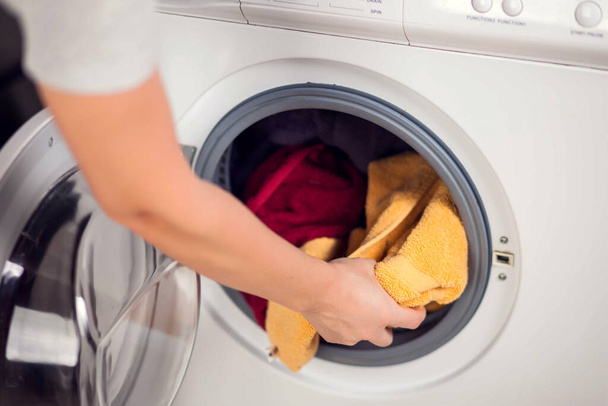 Laden der Kleidung in die Waschmaschine. Hausarbeit, Wäschekonzept - Foto, Bild